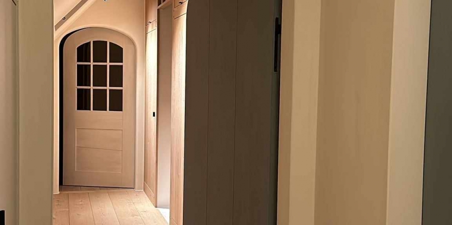 Booggang in een landelijke woning, afgewerkt in warme zandtint