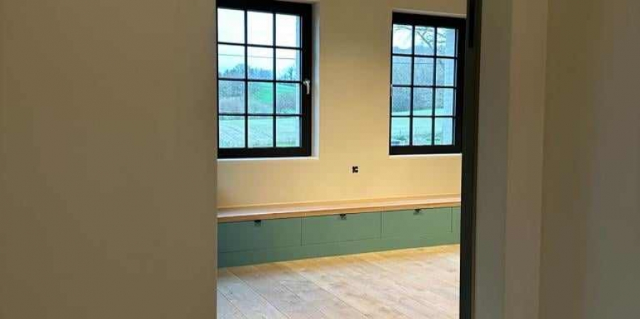 Interieur met salie-groene kasten en geschilderd schrijnwerk